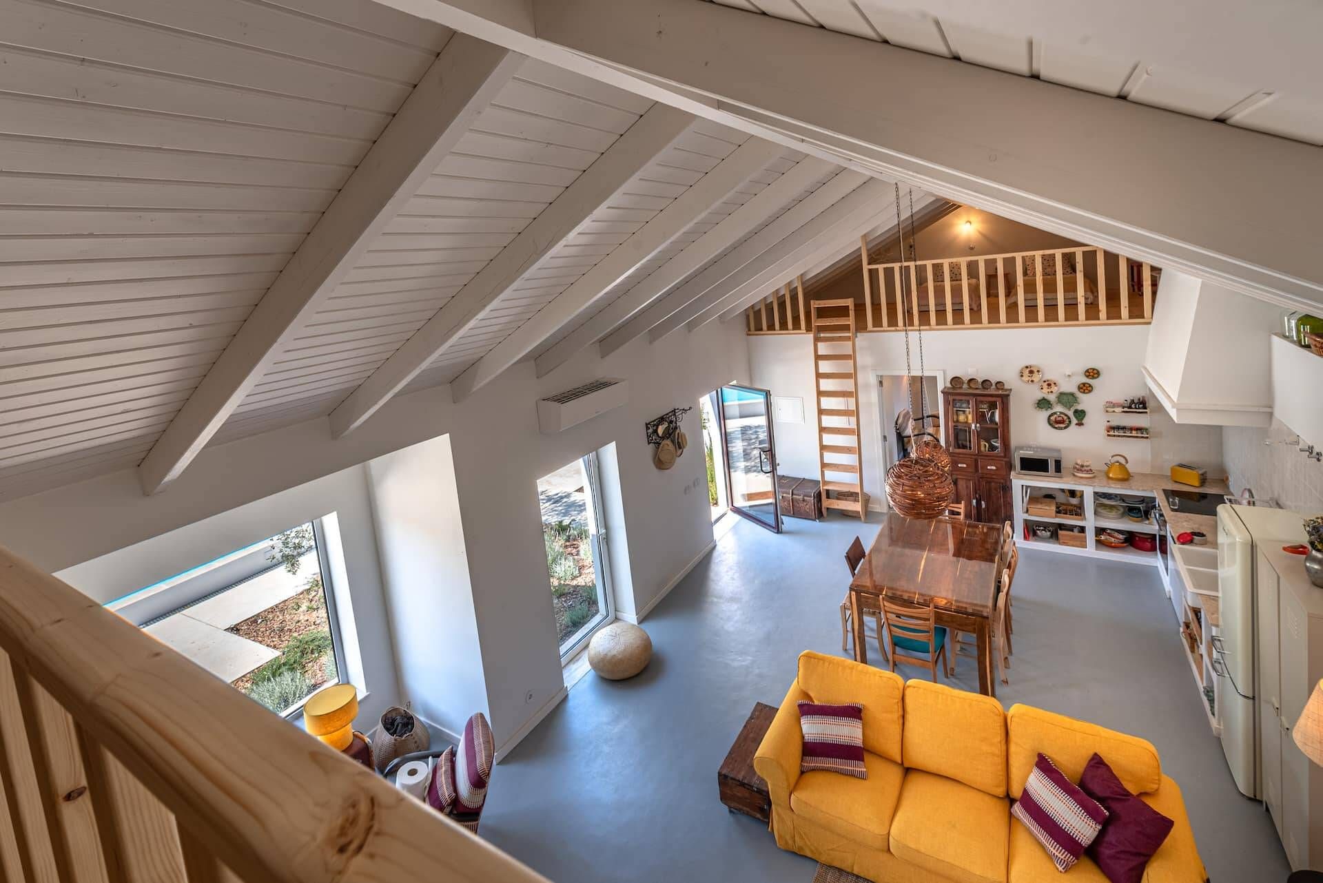A spacious interior with a high ceiling, a dining area, and a kitchen.