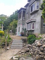 A two-story building with a stone staircase leading to the entrance.