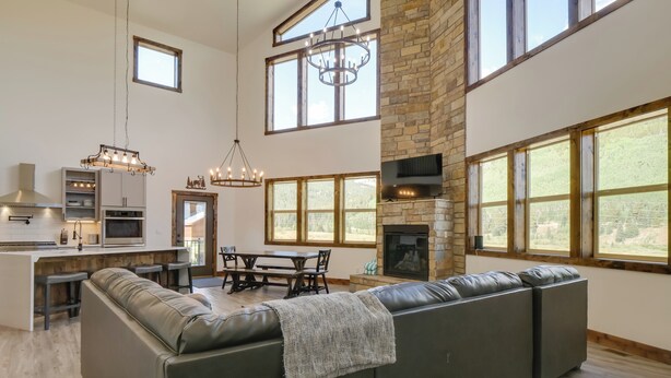 A spacious living area with a large sectional sofa, a fireplace, and a dining area with a table and chairs. - Hot Tub, Pool Table & Fireplace: 5 Mi to Breck! (Blue River)