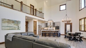 A spacious living area with a large sectional sofa, a dining table with chairs, and a kitchen in the background. - Hot Tub, Pool Table & Fireplace: 5 Mi to Breck! (Blue River)