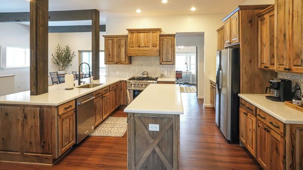 Una cocina amplia con armarios de madera, una isla central y un refrigerador grande.