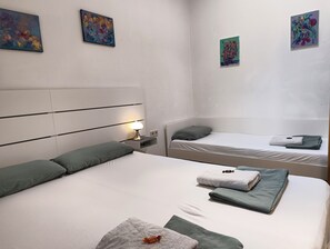 A hotel room with two beds, a nightstand, a lamp, and artwork on the walls. - Stay at the heart of Villach, great outdoor space (Villach)