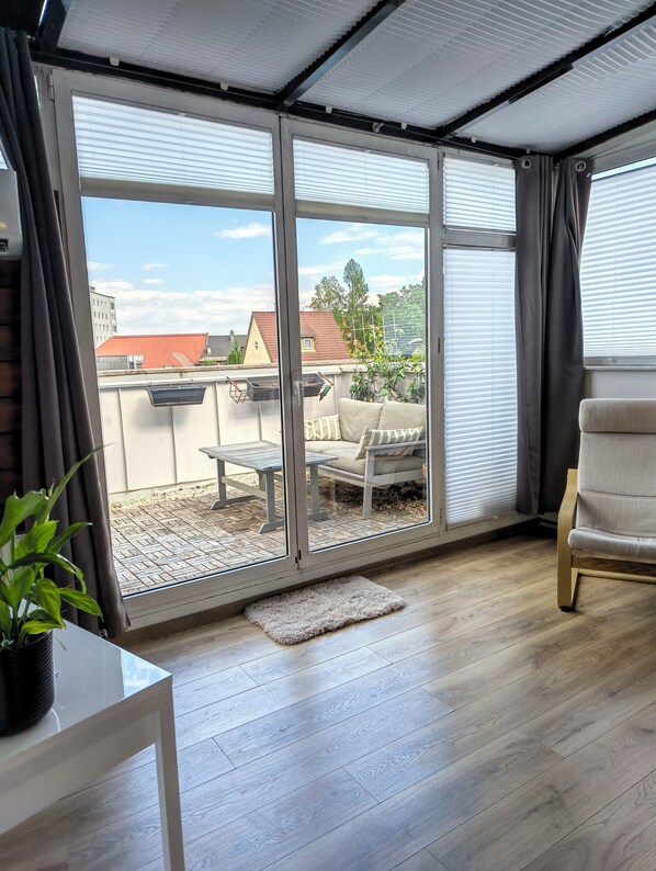 A room with a sliding glass door leading to an outdoor patio area. - Stay at the heart of Villach, great outdoor space (Villach)