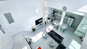 A modern interior with a staircase, seating area, and kitchen.