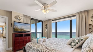 A bedroom with a large bed, a ceiling fan, a TV, and a view of the ocean. - It Doesnt Get Any Better Than This! 2BR 2BA Sleeps 8 Beachfront! (Panama City Beach)