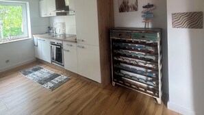 Une cuisine avec des armoires blanches, une armoire en bois et un meuble à bouteilles.