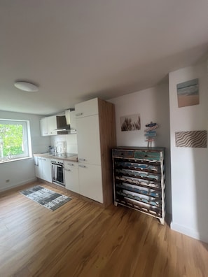A kitchen with white cabinets, a wooden cabinet, and a wine rack.