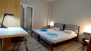 A bedroom with a bed, a desk, and a chair.