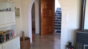 A hallway with a wooden door, a fireplace, and a bookshelf.