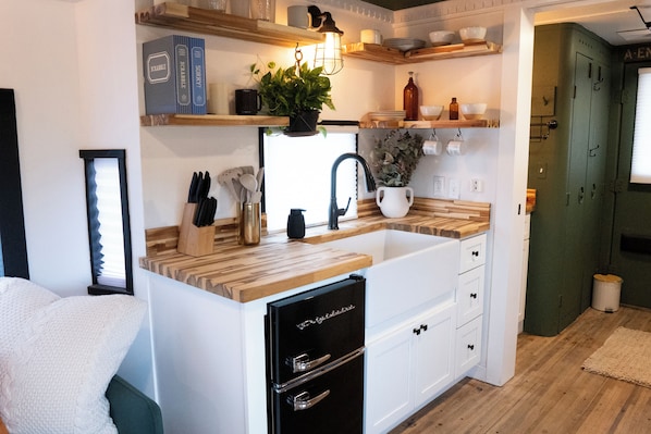 Fridge, microwave, coffee/tea maker, cookware/dishes/utensils