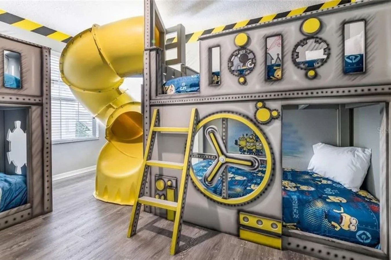 A children's room with bunk beds, a slide, and a clock.