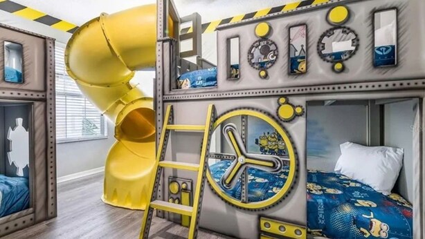 A children's room with bunk beds, a slide, and a clock. - The Minions Mansion 6br Resort Pool Home By Disney (Kissimmee)