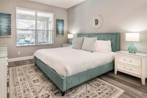 A bedroom with a bed, nightstands, a rug, and artwork on the walls. - The Minions Mansion 6br Resort Pool Home By Disney (Kissimmee)