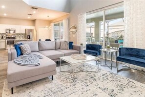 Una sala de estar moderna con un sofá modular, una mesa de centro y un sillón azul.