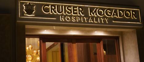 A sign for "Cruiser Mogador Hospitality" with a crown emblem and illuminated lettering.