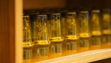 A row of clear glass bottles on a wooden shelf.