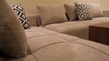 A beige sectional sofa with patterned throw pillows.
