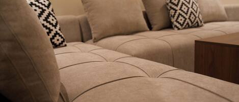 A beige sectional sofa with patterned throw pillows.