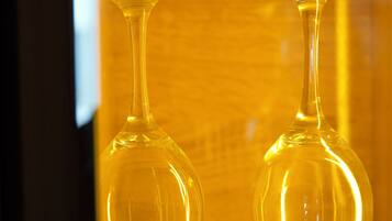 Two clear glass wine glasses in a yellow-lit display case.