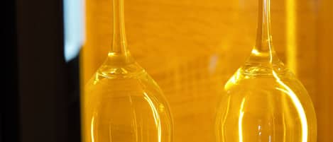 Two clear glass wine glasses in a yellow-lit display case.