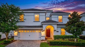 A two-story house with a garage, a front door, and a driveway. - The Magic Kingdom 9BR Resort Pool Home Near Disney (Four Corners)