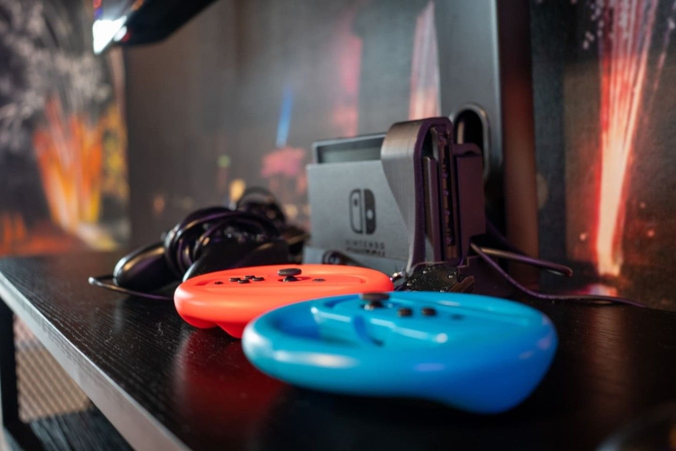 Una consola portátil Nintendo Switch con una correa, colocada sobre una superficie.