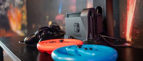 Una consola portátil Nintendo Switch con una correa, colocada sobre una superficie.