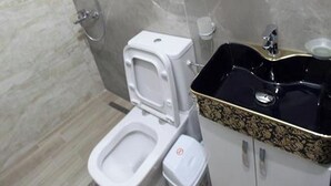 A modern bathroom with a toilet, bidet, and sink. - Vila Anhel (Ksamil)