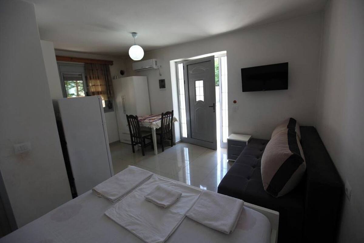 A compact living space with a kitchenette, a dining area, and a sofa.