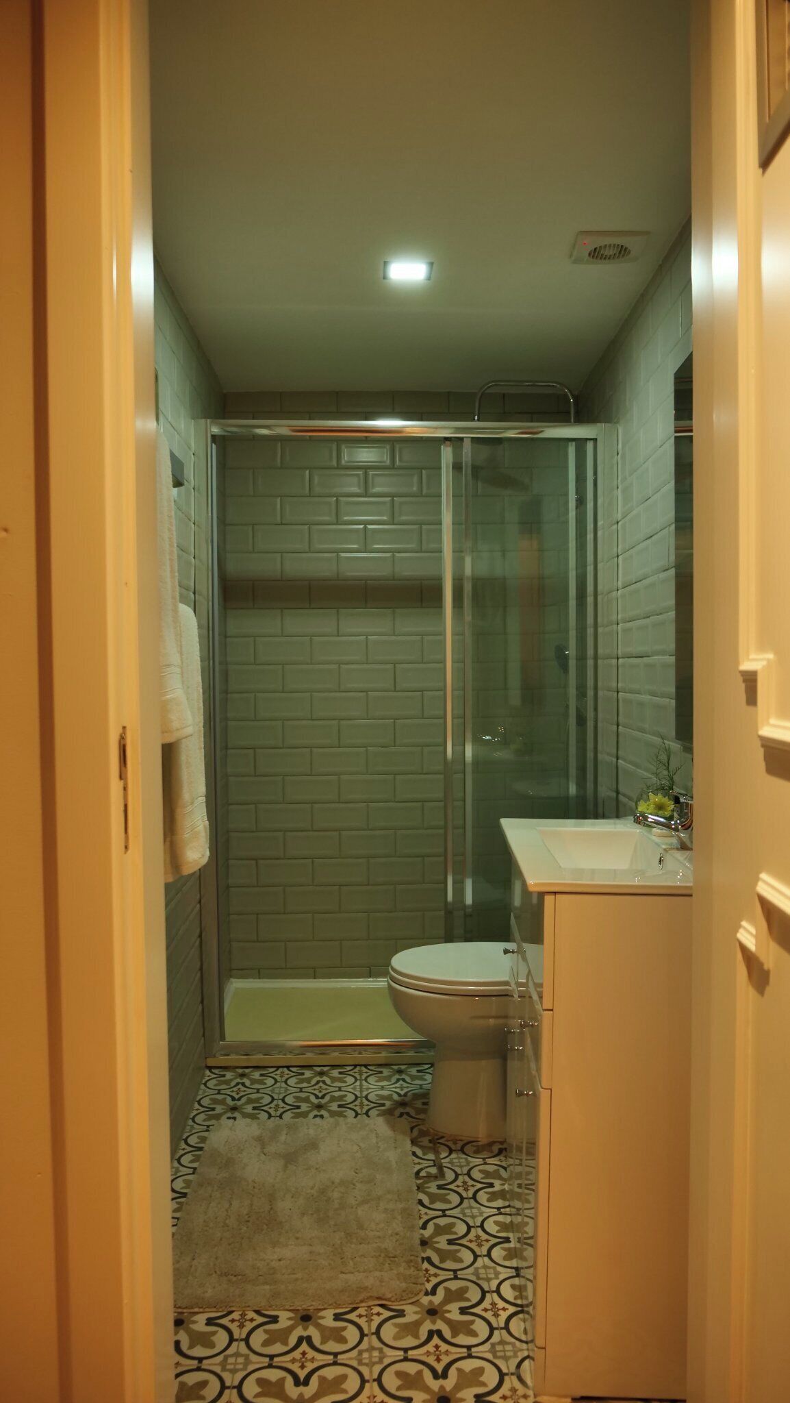 Un baño pequeño con cabina de ducha de vidrio, inodoro y lavabo.
