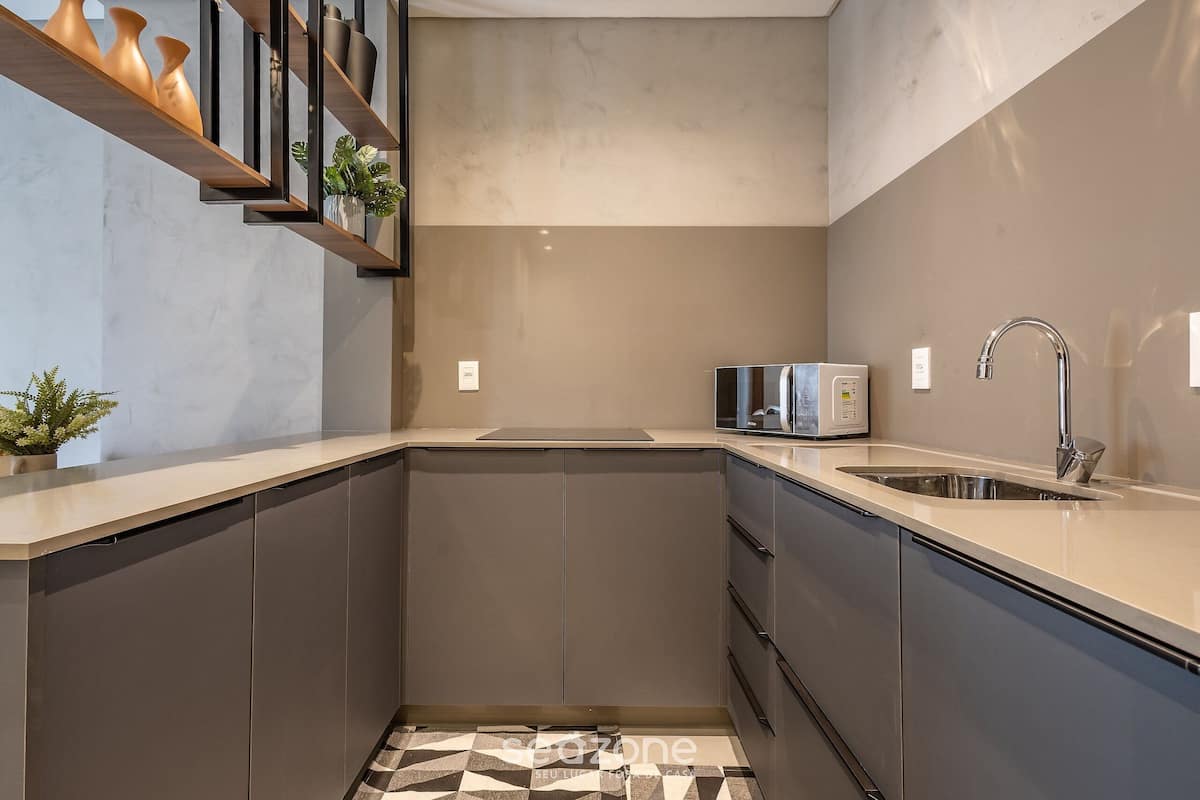 A modern kitchen with a built-in oven, a microwave, and a stainless steel sink.