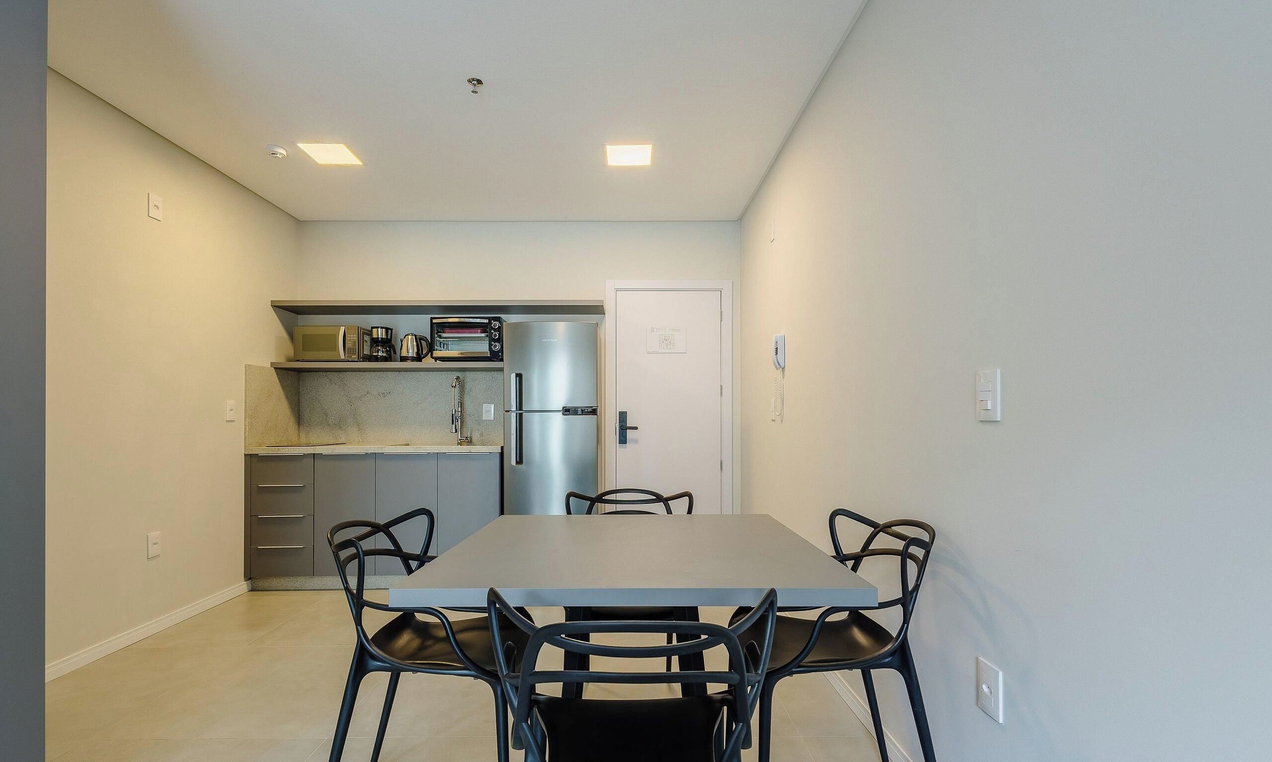 Una cocina compacta equipada con refrigerador, microondas y horno tostador.