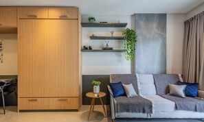 A modern living room with a sofa, a coffee table, and a wooden wardrobe. - Sua estadia exclusiva a poucos passos do Mar em Meia Praia - FFS (Itapema)