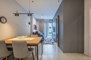 Una sala moderna con comedor, un sofá y un televisor.
