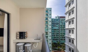 A balcony with a small sink, two air conditioning units, and a heater. - Sua estadia exclusiva a poucos passos do Mar em Meia Praia - FFS (Itapema)