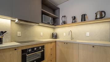 Uma cozinha moderna com eletrodomésticos embutidos, pia de aço inoxidável e armários de madeira.
