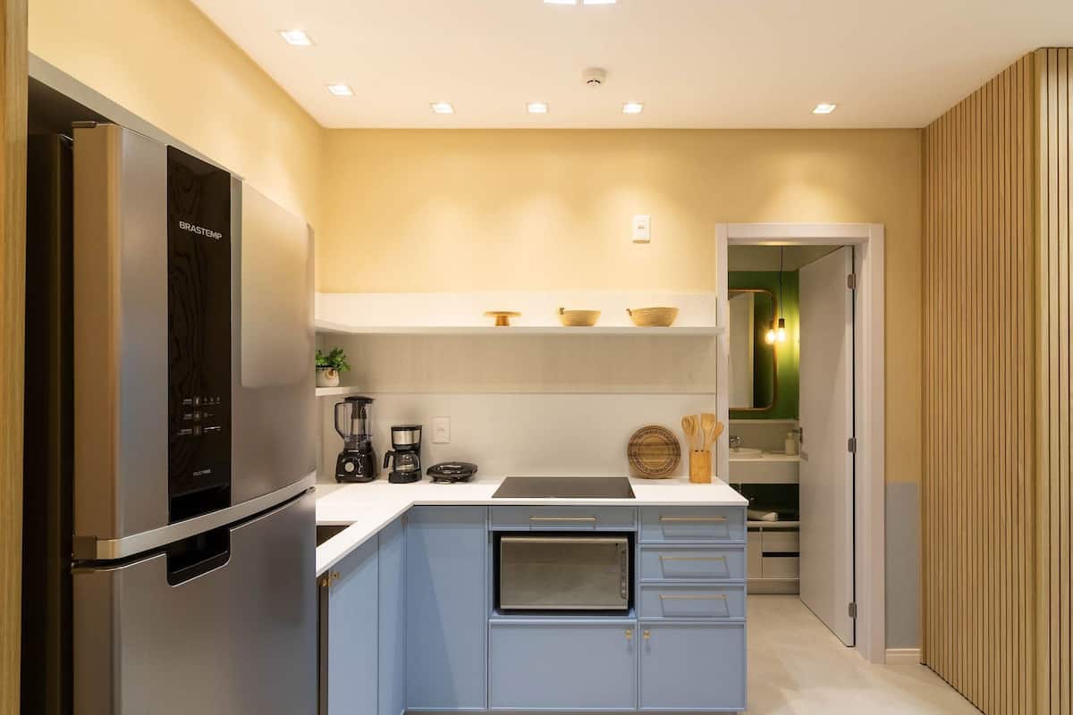 A modern kitchen with a built-in oven, a refrigerator, and a coffee maker.