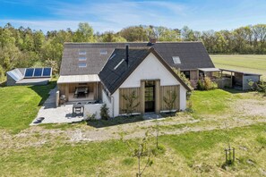 Ein modernes Haus mit Satteldach, Terrasse und Solaranlage.