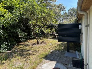 A pathway leading to a building with a metal structure on the right. - Holiday on lovely nature plot for families (Hadsund)