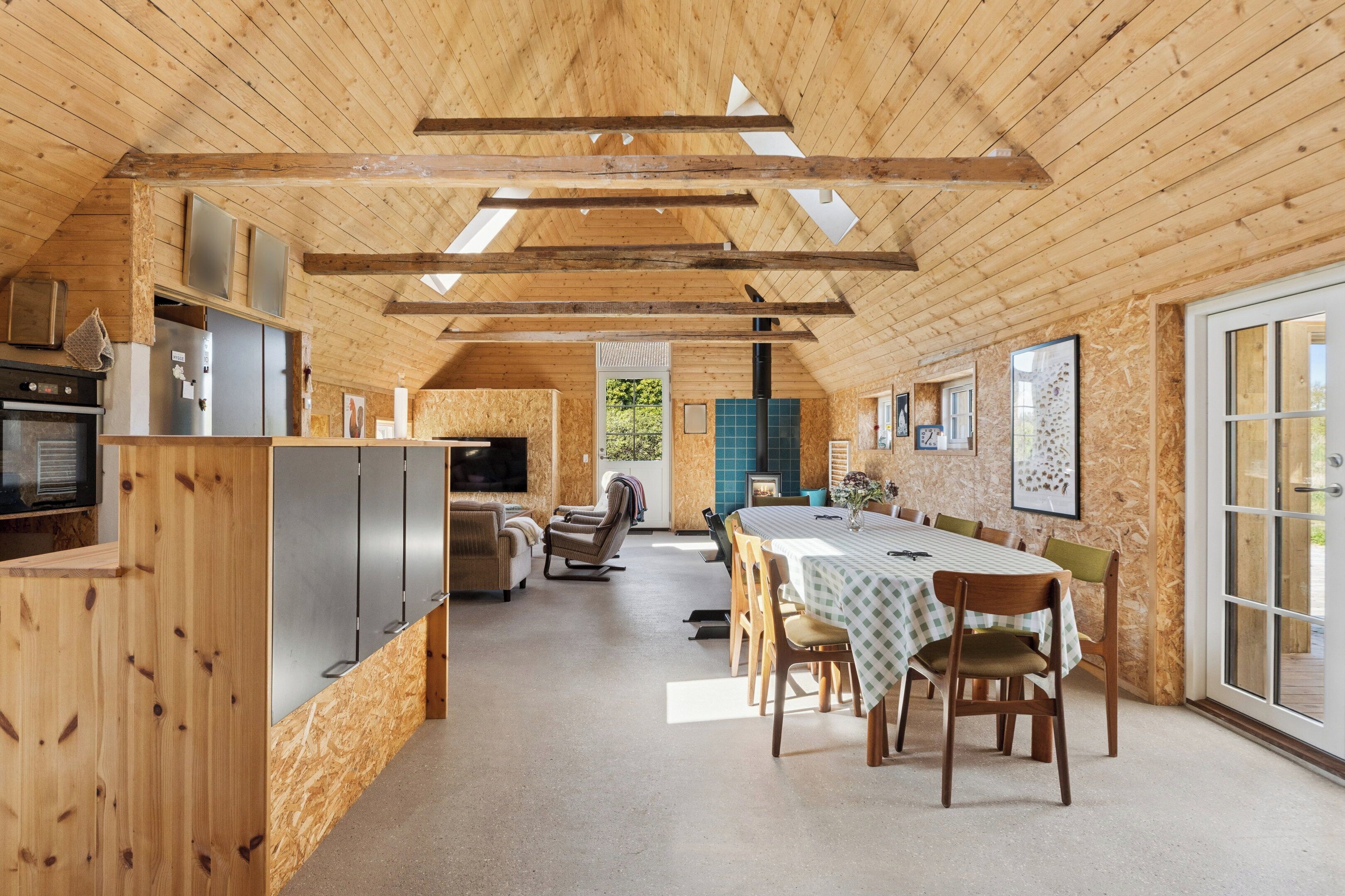 A wooden interior with a dining area, kitchen, and seating.