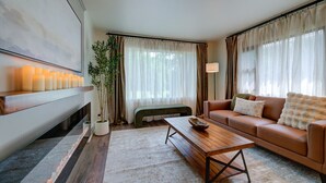 Una sala de estar con un sofá, una mesa de centro, un banco y una chimenea.
