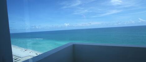 A balcony with a view of the ocean and beach.