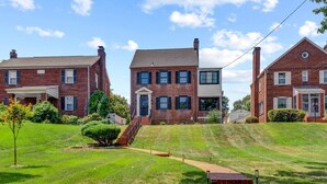 A residential area with brick houses, a well-maintained lawn, and a clear sky. - Private DC Studio | Free Parking + W/D (Washington)