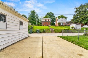 A residential area with a concrete driveway, a small grassy yard, and a fence. - Chic DC Estate - Free Parking, Patio, Sleeps 8 (Washington)