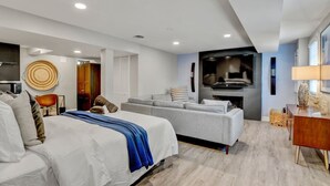 A modern bedroom with a bed, sofa, TV, and a dining area. - Private DC Studio | Free Parking + W/D (Washington)
