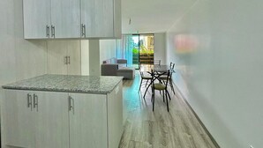 Une cuisine moderne avec des meubles blancs et un plan de travail en granit.