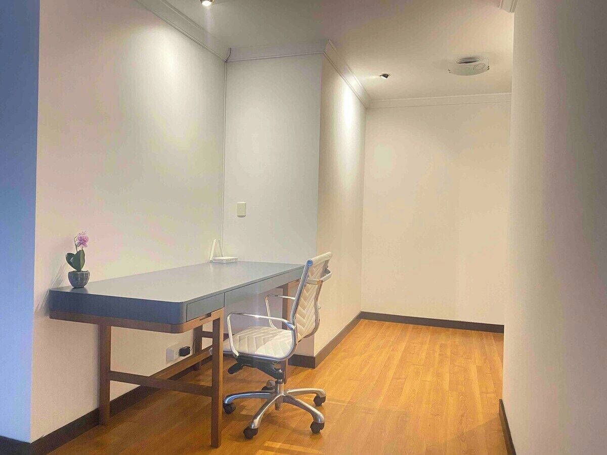 Une salle de conférence avec une longue table, une chaise moderne et une petite plante en pot.