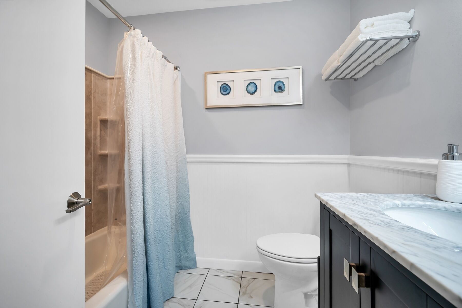 A bathroom with a shower, toilet, and vanity.