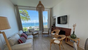 Una sala de estar con sofá, sillas, televisor y chimenea.