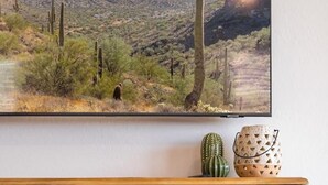 A wooden console table with woven baskets and a cactus decoration.